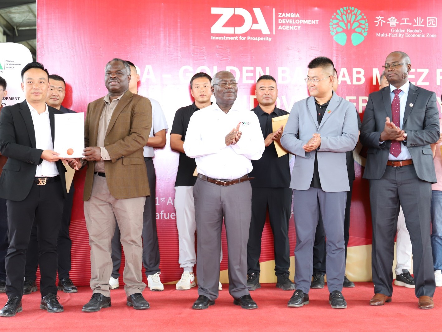 ZDA Director General Albert Halwampa handing over an MFEZ Permit to one of the Investors in the Golden Baobab MFEZ